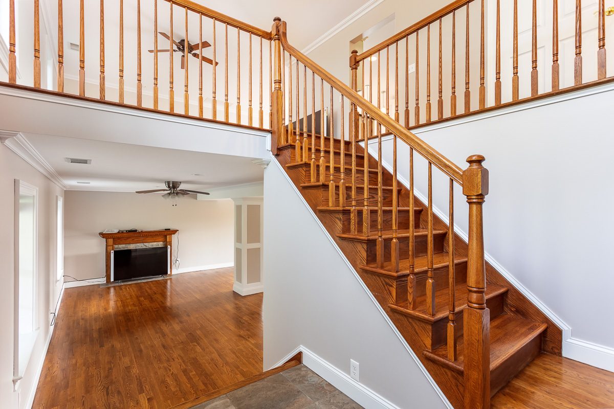 Two-story staircase and family room repainted in a Monroe, NY colonial